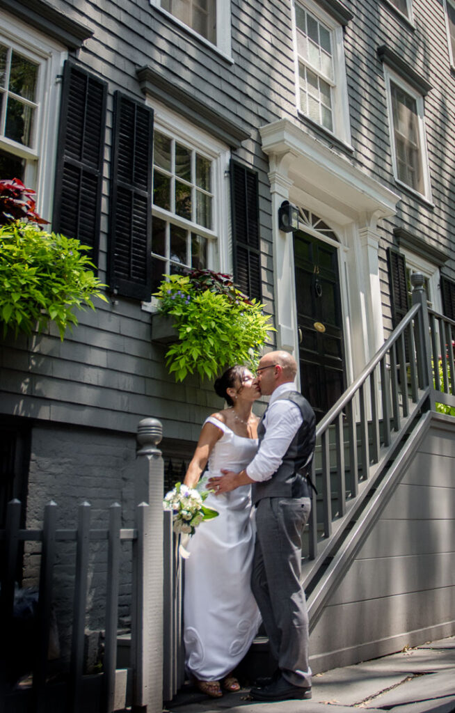 Bride kissing groom by townhouse in Brooklyn Heights